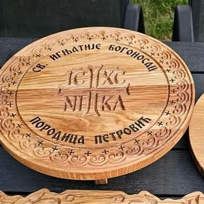 Okrugli drveni stalak s ukrašenim rubom, natpisom slave i prezimenom porodice